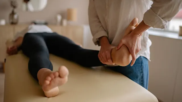 Therapist working pressure points on a client's foot during reflexology