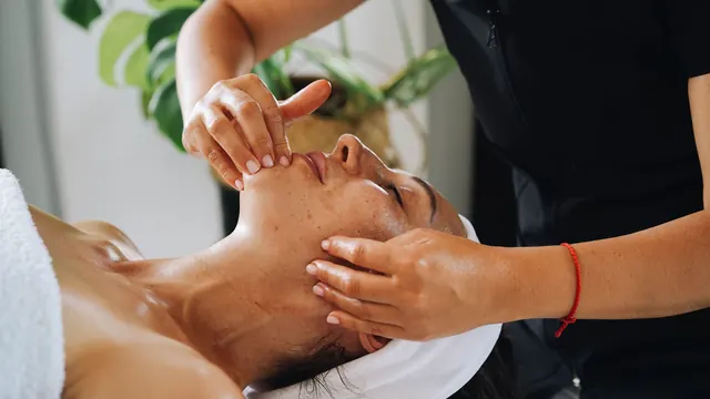 Therapist gently massaging a client's jaw and chin